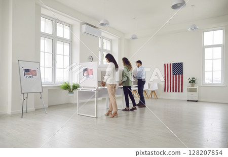 Election day, us polling office, voters stand, participate to mark ballot paper in booth 128207854