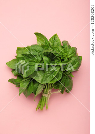 Raw green organic basil leaves on pink background. Raw green organic basil leaves on pink background. 128208205