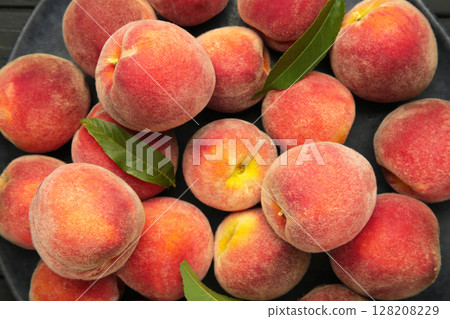 Ripe red peaches with green leaf. Macro photo 128208229