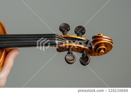 An elegant violin showcasing its intricate design and craftsmanship, perfect for music enthusiasts and artists. 128210689