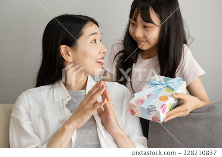 A girl giving a present to my mother 128210837
