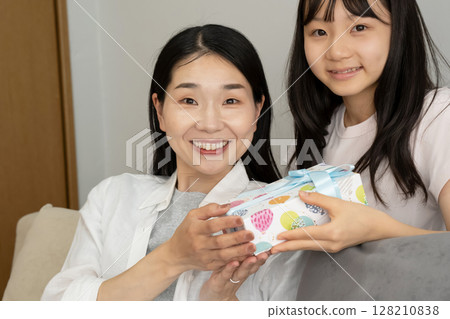 A girl giving a present to my mother 128210838