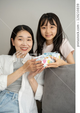 A girl giving a present to my mother 128210839