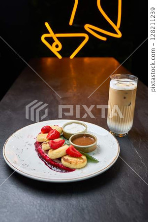 Strawberry mini pancakes with sauces and iced latte 128211239