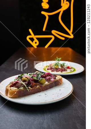 Gourmet open-faced steak sandwich in modern bistro Gourmet open-faced steak sandwich in modern bistro 128211243