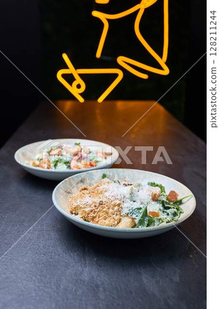 Crispy Chicken and Shrimp Caesar Salads on Table Crispy Chicken and Shrimp Caesar Salads on Table 128211244