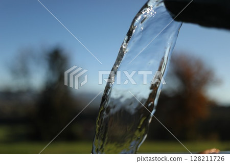 Stream of water is flowing from a faucet Stream of water is flowing from a faucet 128211726