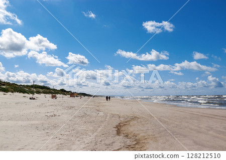 Curonian spit on a sunny summer day. Scenic view of the beach on the Baltic Sea coast in the village of Nida, Lithuania. Gray sand dunes. Curonian spit on a sunny summer day. Scenic view of the beach on the Baltic Sea coast in the village of Nida, Lithuania. Gray sand dunes. 128212510