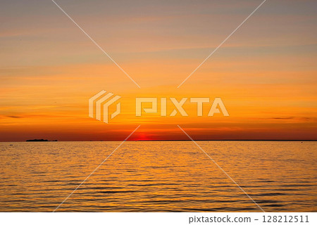 Calm sunset over the sea. The sky is painted with bright colors. Beautiful summer evening at the beach. Calm sunset over the sea. The sky is painted with bright colors. Beautiful summer evening at the beach. 128212511