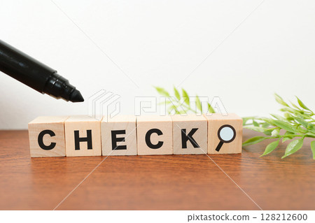 Text and magnifying glass on wooden blocks representing the concept of checking Text and magnifying glass on wooden blocks representing the concept of checking 128212600
