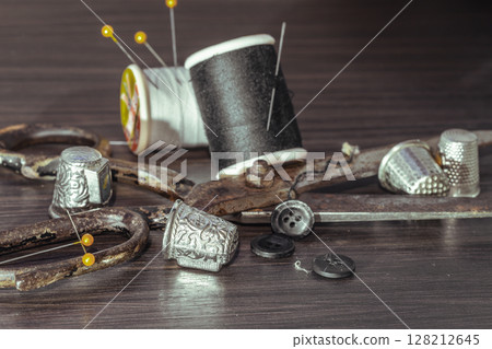 Sewing needles, Thimbles, Scissors, Measuring tape, Buttons, Spools of black and white thread including pins. 128212645