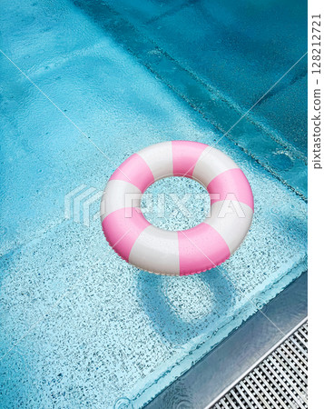 Swimming ring with pink and white stripes in a blue outdoor pool. Poolside atmosphere. Pink float. 128212721