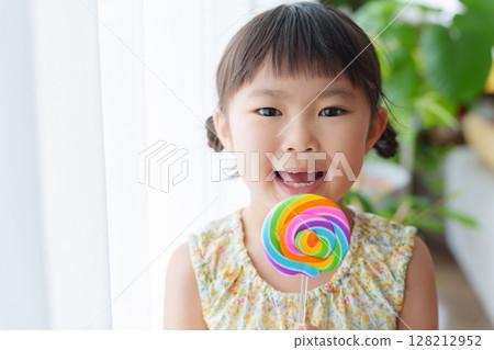 Child eating candy 128212952