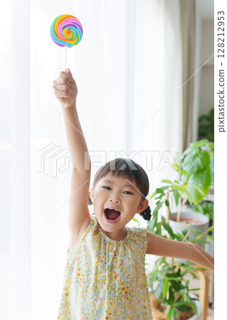 Child eating candy 128212953