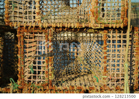 Crab Traps Stacked on a Dock Near the Water During Crab Traps Stacked on a Dock Near the Water During 128213500