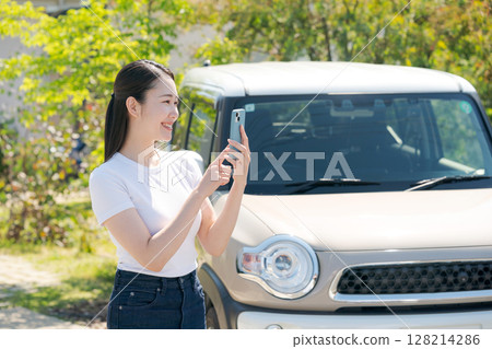 A young woman standing in front of a car A young woman standing in front of a car 128214286