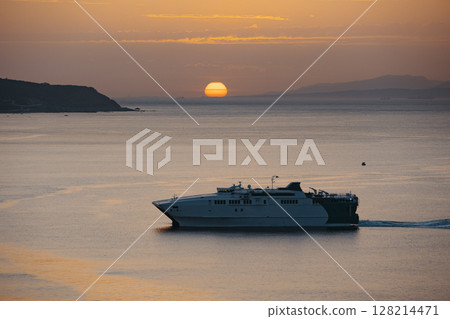 View of a ferry at sunset entering the port of Ceuta View of a ferry at sunset entering the port of Ceuta 128214471