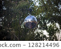 View of a disco ball hanging on a festival stage located in a forest 128214496