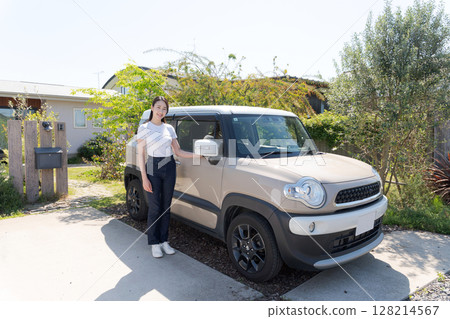 一名二十多歲的女子站在一輛汽車旁邊 一名二十多歲的女子站在一輛汽車旁邊 128214567