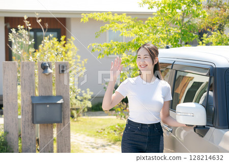 Woman waving next to a car 128214632