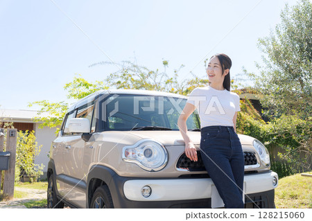 A woman standing in front of a car 128215060