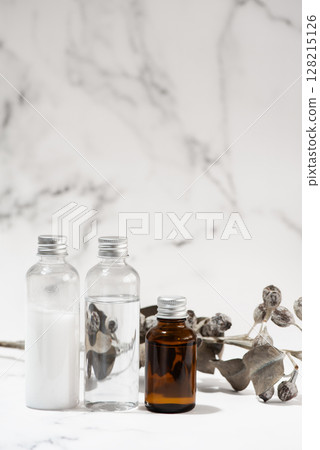 Dried flowers and cosmetic bottles arranged against a marble background 128215126