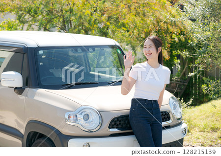 一名女子在一輛汽車前揮手 128215139
