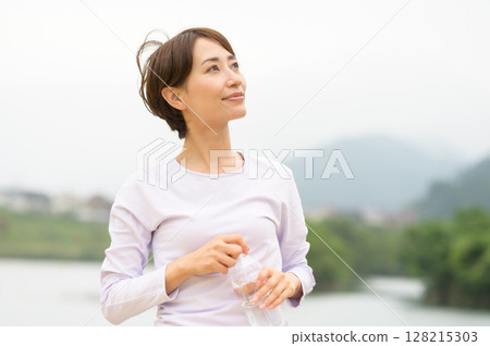 Woman hydrating in the park Woman hydrating in the park 128215303