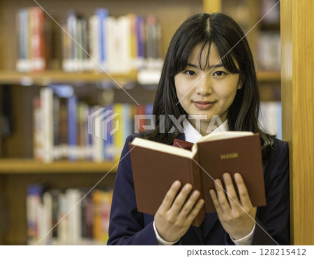 高中女生在圖書館看書 | 一位聰明、冷靜、微笑的學生的肖像 高中女生在圖書館看書 | 一位聰明、冷靜、微笑的學生的肖像 128215412