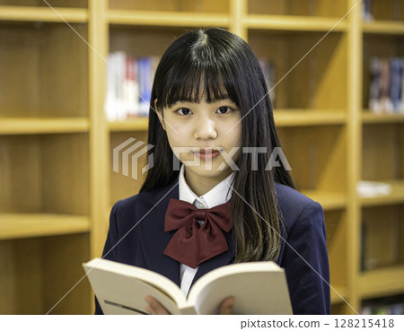 Portrait of a high school girl reading books | Studying in a library 128215418