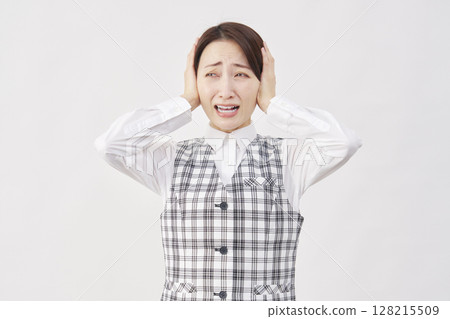 Female office worker covering her ears white background Female office worker covering her ears white background 128215509