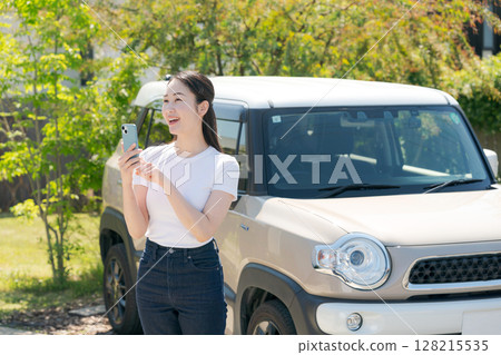 一名二十多歲的女子站在一輛汽車前 128215535