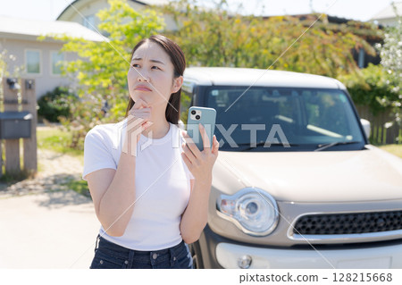 一名二十多歲的女子站在一輛汽車前 128215668