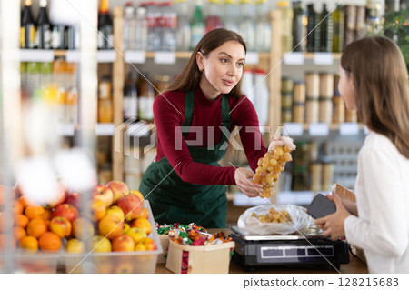 Woman seller offering grapes 128215683