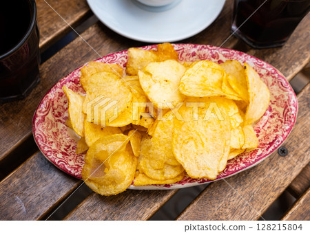 Round potato chips served in plate with a glass of vermouth Round potato chips served in plate with a glass of vermouth 128215804