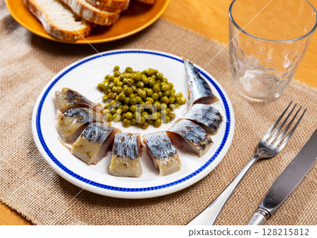 Fried scomber carcass, complemented with green peas Fried scomber carcass, complemented with green peas 128215812