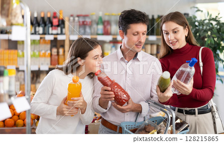 Family with teenage girl choosing non-alcoholic drinks in grocery Family with teenage girl choosing non-alcoholic drinks in grocery 128215865
