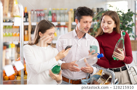 Man woman and girl scans QR code of soda Man woman and girl scans QR code of soda 128215910