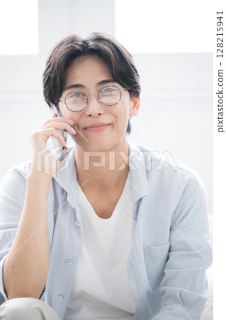 Close-up of handsome man with glasses holding smartphone, looking at camera, making phone call, talking or talking image, "If 128215941