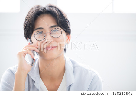 Close-up of handsome man with glasses holding smartphone, looking at camera, making phone call, talking or talking image, "If 128215942