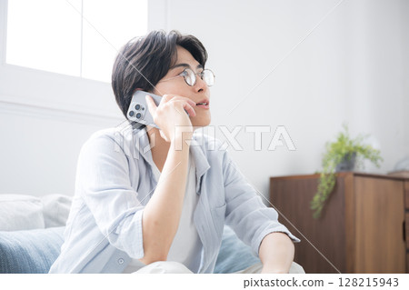 Close-up of handsome man with glasses holding smartphone, making a phone call, image of calling or speaking "Hello~" Close-up of handsome man with glasses holding smartphone, making a phone call, image of calling or speaking "Hello~" 128215943