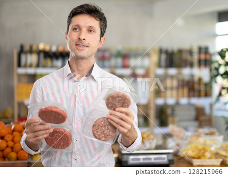 man chooses packages of hamburger patties 128215966