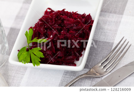 Portion of salad made of boiled and grated beetroot 128216009