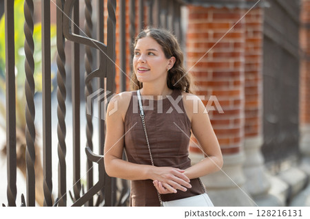 Beautiful young female tourist dressing in short dress walking and posing near Hospital de la Santa Creu i Sant Pau in Barcelona Beautiful young female tourist dressing in short dress walking and posing near Hospital de la Santa Creu i Sant Pau in Barcelona 128216131