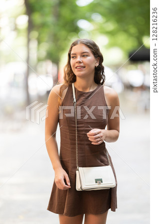 Young woman walking around summer european city 128216236