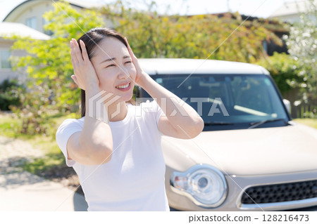 Woman holding her head next to her car Woman holding her head next to her car 128216473