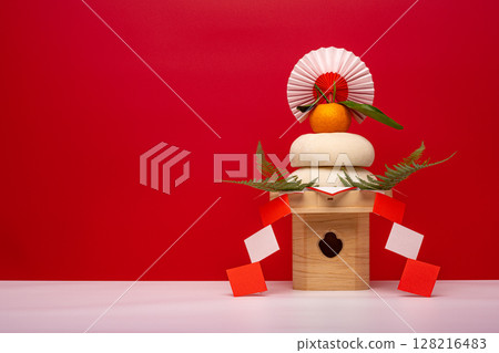 右邊的照片中，紅色背景上放置著一塊真正的年糕“鏡餅”，旁邊還有一塊三寶（底座）。 128216483