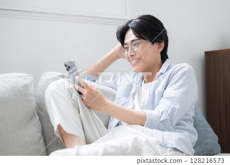 戴眼鏡的英俊男子看著智慧型手機 128216573