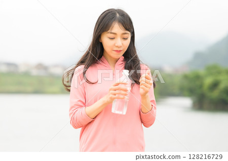 在公園裡補水的女人 128216729