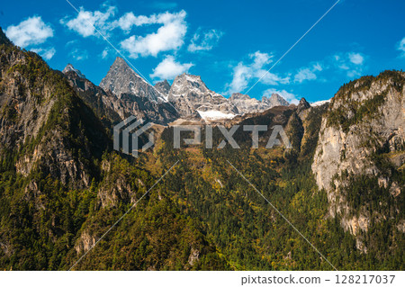 Majestic Snow-Capped Mountain Peaks under a Blue Sky at Balagezong 128217037
